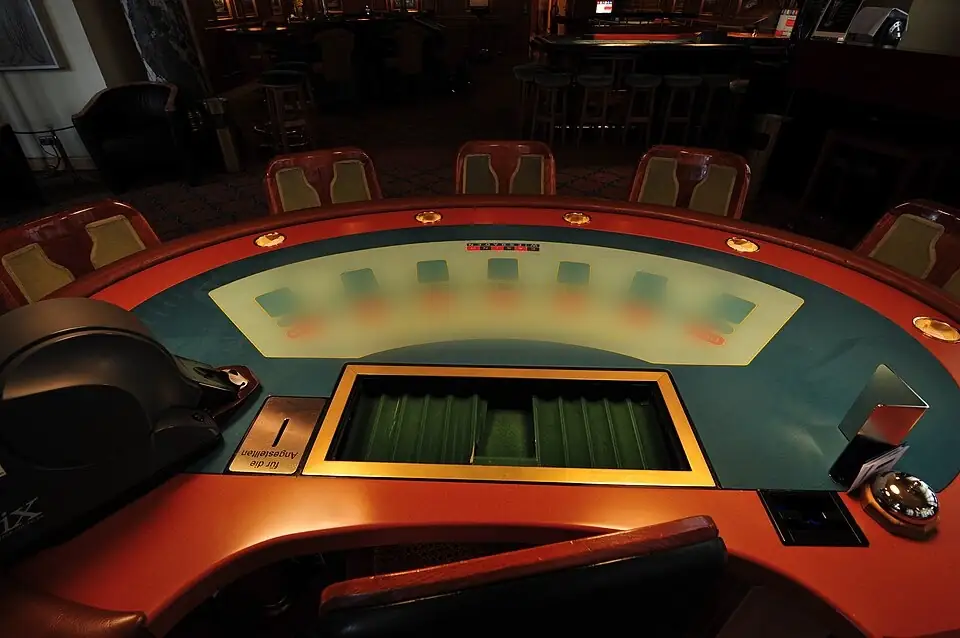 Üres félkörös blackjack-asztal az osztó oldaláról, zsetontálcával és párnázott karfával